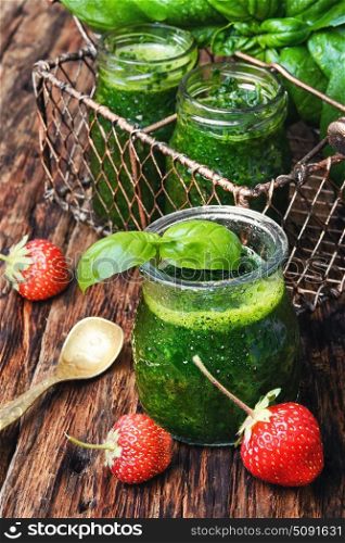 Smoothies with basil and strawberry. Freshly blended basil and strawberry smoothie in glass jar