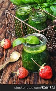 Smoothies with basil and strawberry. Freshly blended basil and strawberry smoothie in glass jar