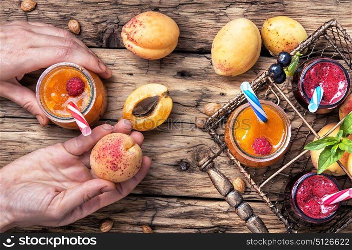 Smoothies with fruit. hand with jar of apricot smoothies on table in a rustic style