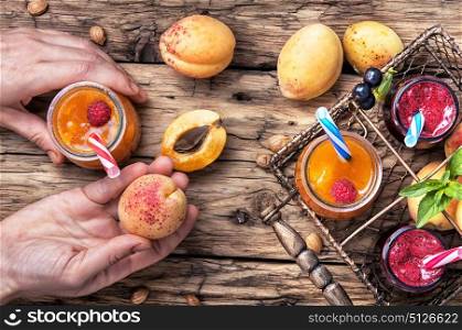 Smoothies with fruit. hand with jar of apricot smoothies on table in a rustic style