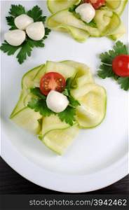 Snack in the form of roses from zucchini , mozzarella and cherry tomatoes