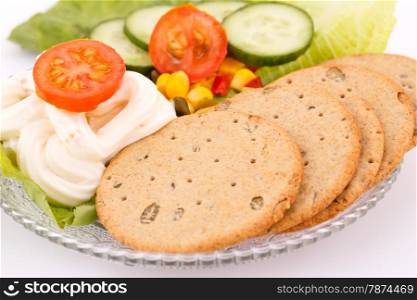 Snack with vegetables and crackers on plate.