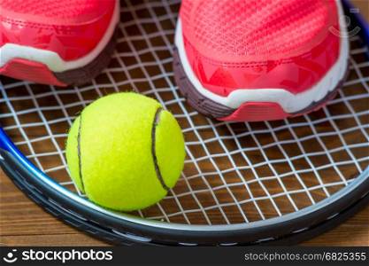 Sneakers and tennis ball on a racket close-up