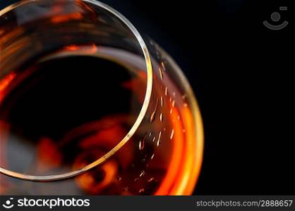 snifter of brandy in elegant glass. black background