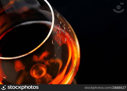 snifter of brandy in elegant glass. black background