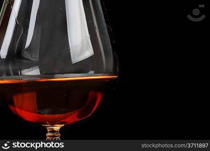 snifter of brandy in elegant glass. black background