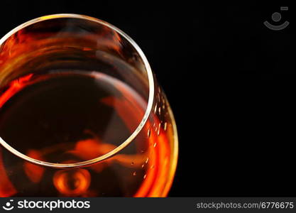 snifter of brandy in elegant glass. black background