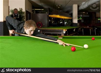 Snooker player lining up the cue and cue ball for a shot