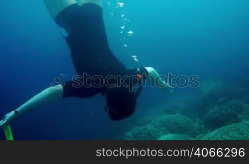 Snorkeler diving swimming under water.