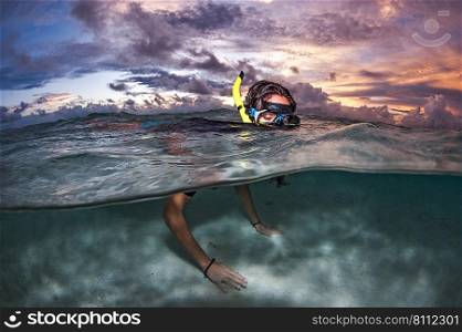 Snorkelling at Sunset in the cristal clear waters of Maldives. Snorkeling in Maldives