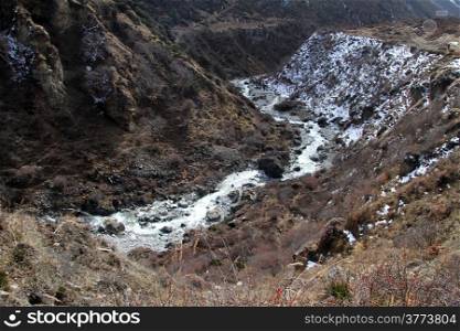 Snow and river in mountain near Samdo in Nepal