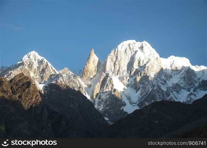 Snow capped mountains Lady's Finger and Hunza peak lit by morning sunlight. Hunza valley, Gilgit Baltistan, Pakistan.