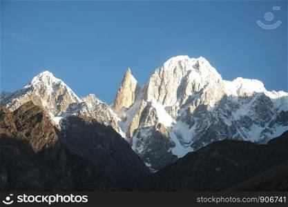Snow capped mountains Lady's Finger and Hunza peak lit by morning sunlight. Hunza valley, Gilgit Baltistan, Pakistan.