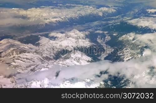 Snow-capped mountains view made from the board of the plane.