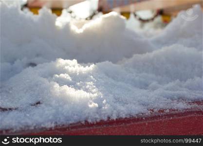 Snow closeup on a red wooden background