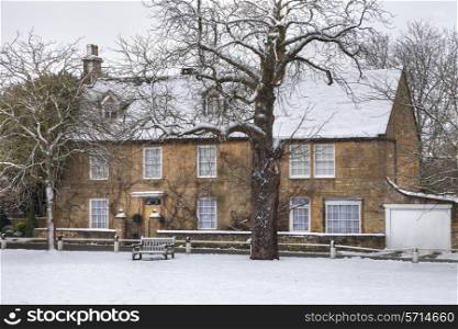 Snow covered character property overlooking the village green, Broadway, Worcestershire, England.