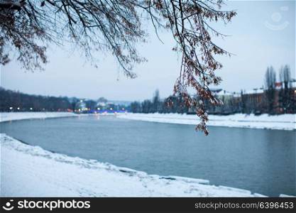 Snow-covered embankment in evening city. Beautiful winter landscape. Night view of snow-covered embankment