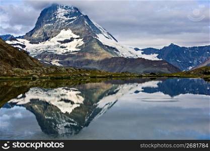Snow-covered mountain reflected in tranquil lake