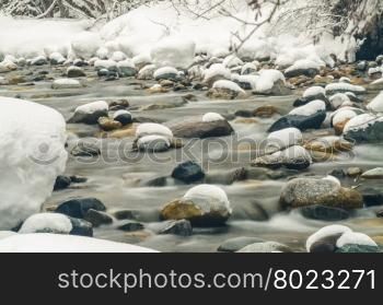 Snow-covered mountain river shot with long exposure