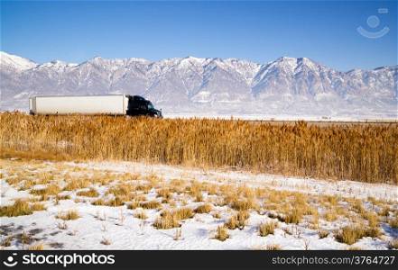 Snow Covered Mountains Behind Lakeside Highway PLant Growth Utah Landscape