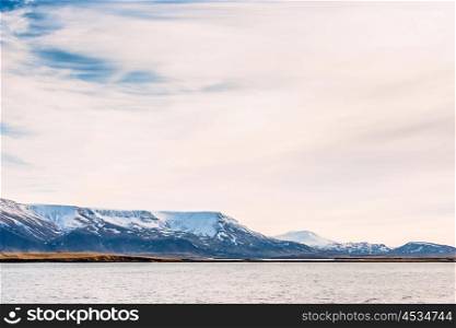 Snow covered mountains in the sea near Iceland