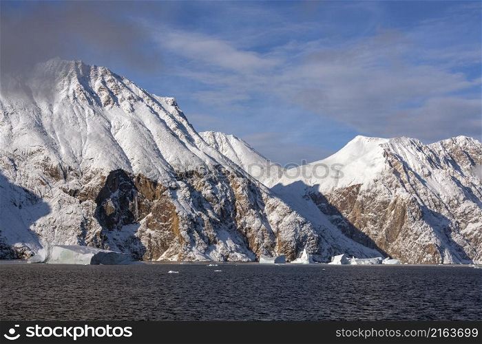 Snow covered mountains on the coast of Scoresbysund in eastern Greenland.