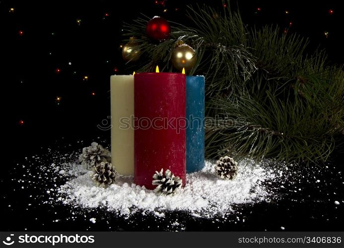 Snow covered ornaments with candles and fir tree branch