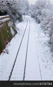 Snow covered railway tracks and stop light
