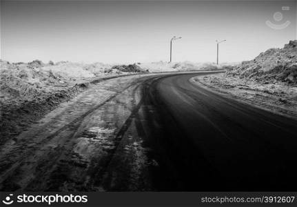 Snow-covered road, the marks of wheels, black and white photo
