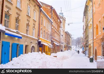 Snow covered street of Lviv old town with cafes and restaurants, winter Lviv cityscape, Ukraine