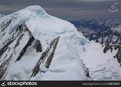Snow-covered summit in the middle of mountain landscape