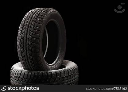 Snow-covered winter tyre covers, isolated on a black background