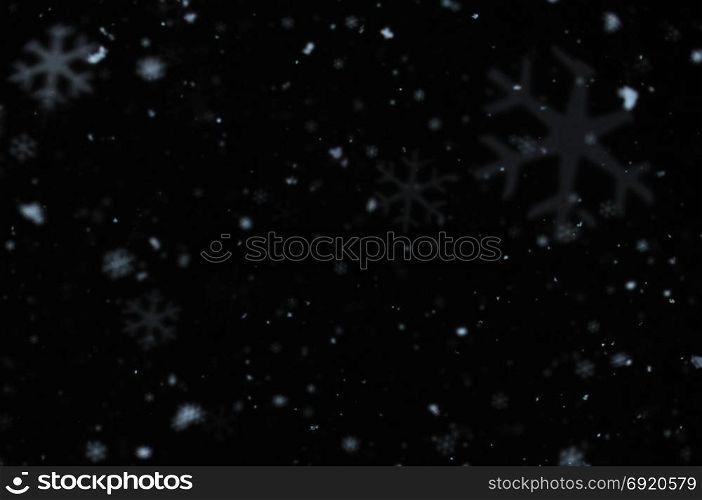 Snow falling on cold winter night. Snowflakes bokeh blur effect abstract background.