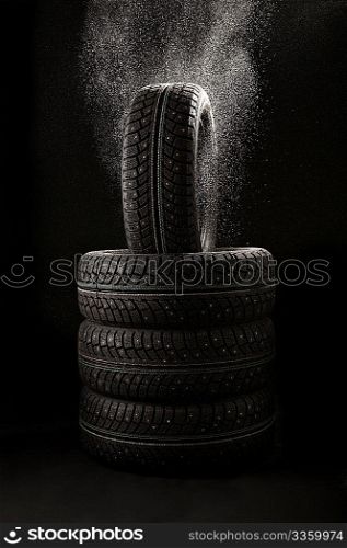 Snow falls on a pile of winter tyre covers