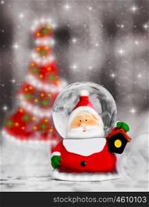 Snow globe Santa Claus, Christmas tree decoration, traditional winter holiday ornament with shiny blur lights background, selective focus