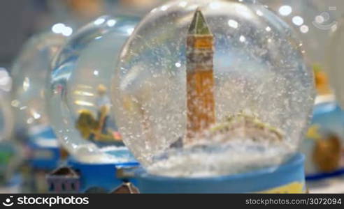 Snow globes in the store. Focus on the souvenir with St Marks Campanile and moving snowflakes inside