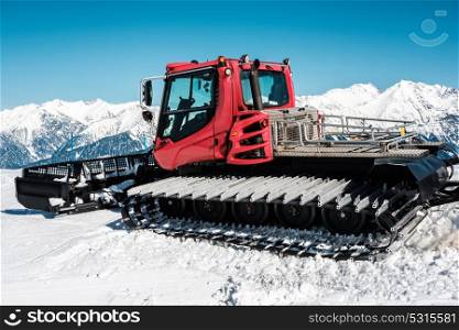Snow grooming machine (Ratrak). Winter mountain landscape. Caucasus ridge covered with snow in sunny day. Krasnaya Polyana, Sochi, Russia