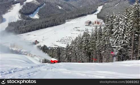 snow gun shoots, sideways moving ski lifts in Carpathian Mountains, winter