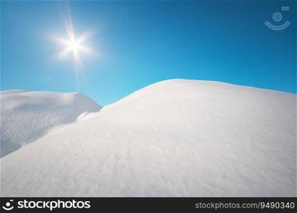 Snow hills and deep blue sunny sky. Winter nature composition.