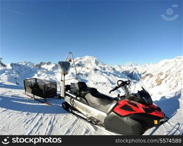 snow mobile sledge parked at mountaint top at beautiful winter sunny day