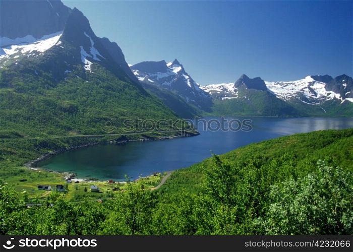 Snow mountain and blue lake in norway