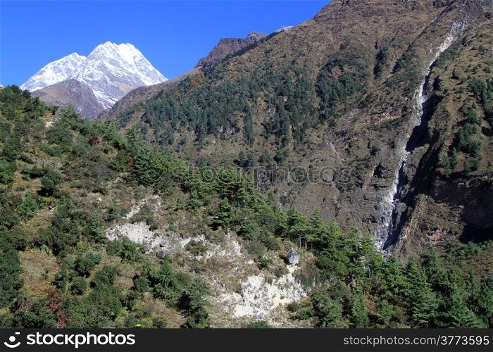 Snow mountain and narrow waterfall in Nepal