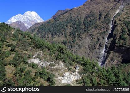 Snow mountain and narrow waterfall in Nepal
