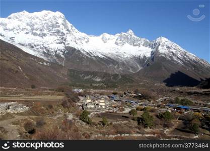 Snow mountain Manaslu and village Samagoon in Nepal