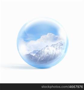 Snow mountains inside a glass ball. A glass transparent ball with snow high mountains inside it.