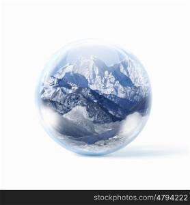 Snow mountains inside a glass ball. A glass transparent ball with snow high mountains inside it.