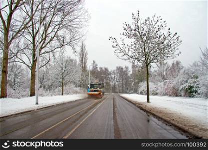 Snow plow cleaning the road in the countryside from the Netherlands in winter