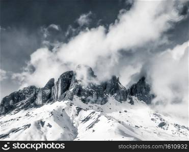 Snow storm over the typical rugged summit formations in the Italian dolomite mountains, blue toned picture. Snow storm over the dolomite mountains