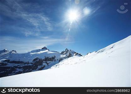 Snow-topped mountain peaks under the sun