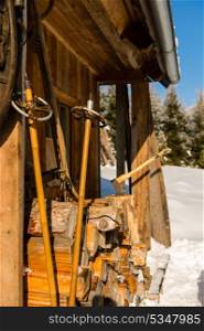 Snow winter cottage from outside ski poles, logs of wood
